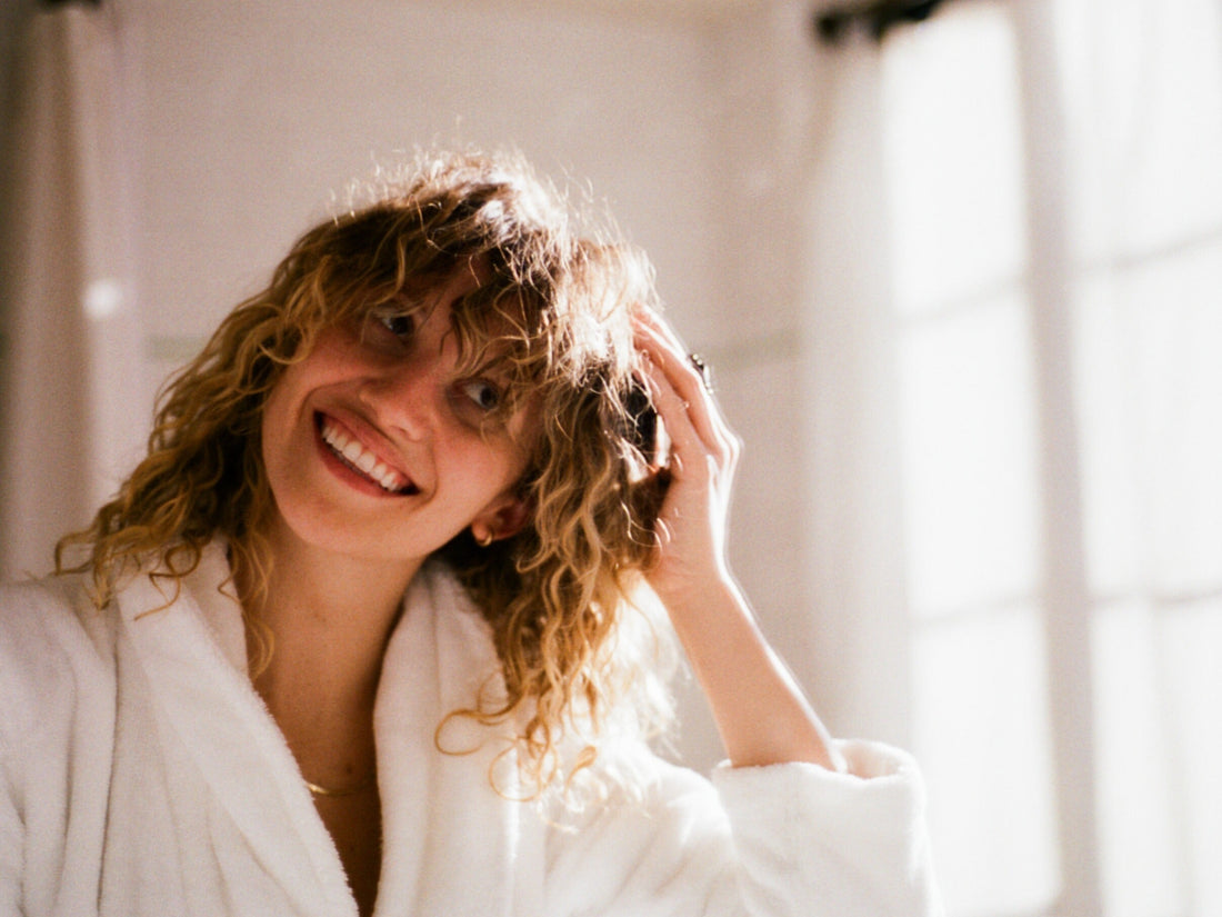 Image of a woman enjoying her clean, curly hair after showering