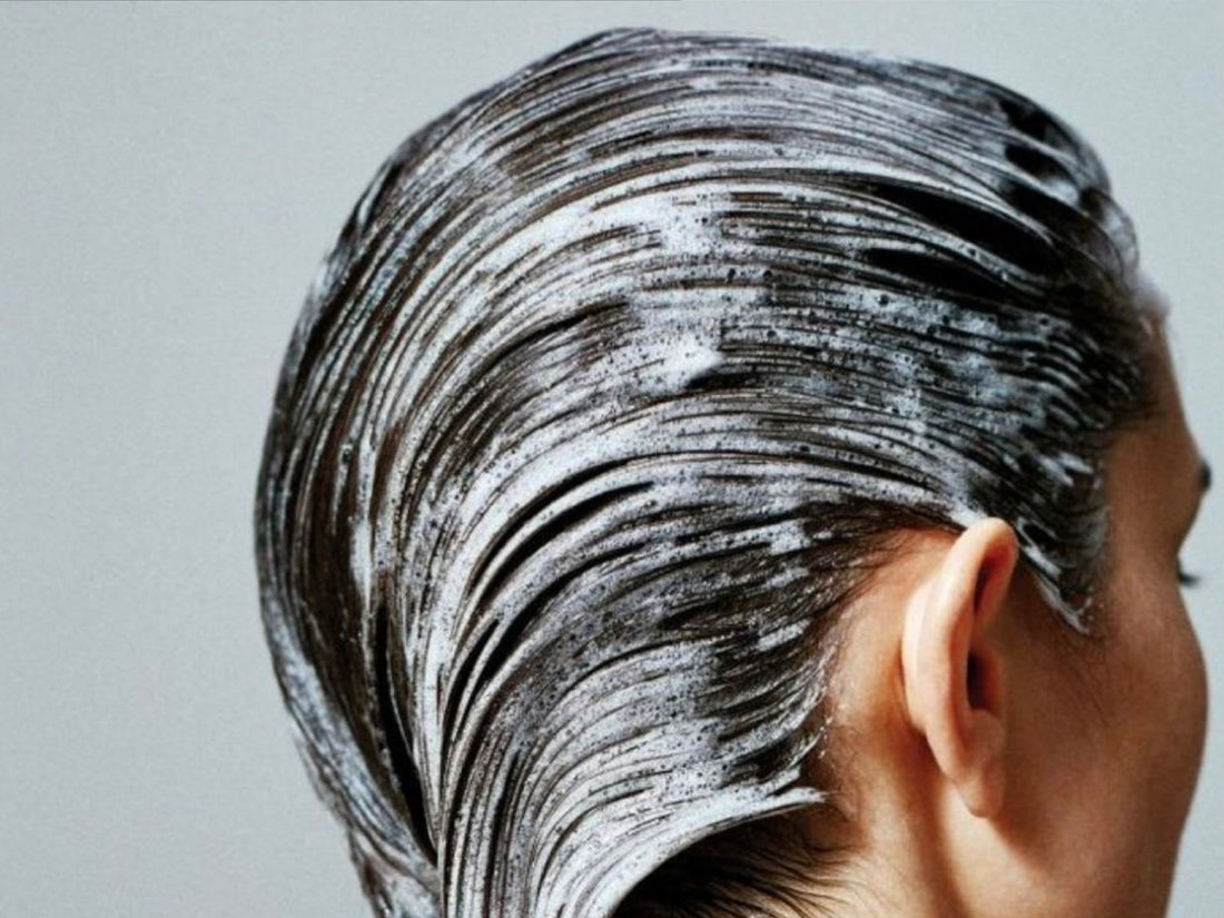 Image of a woman with shampoo on her long, black hair