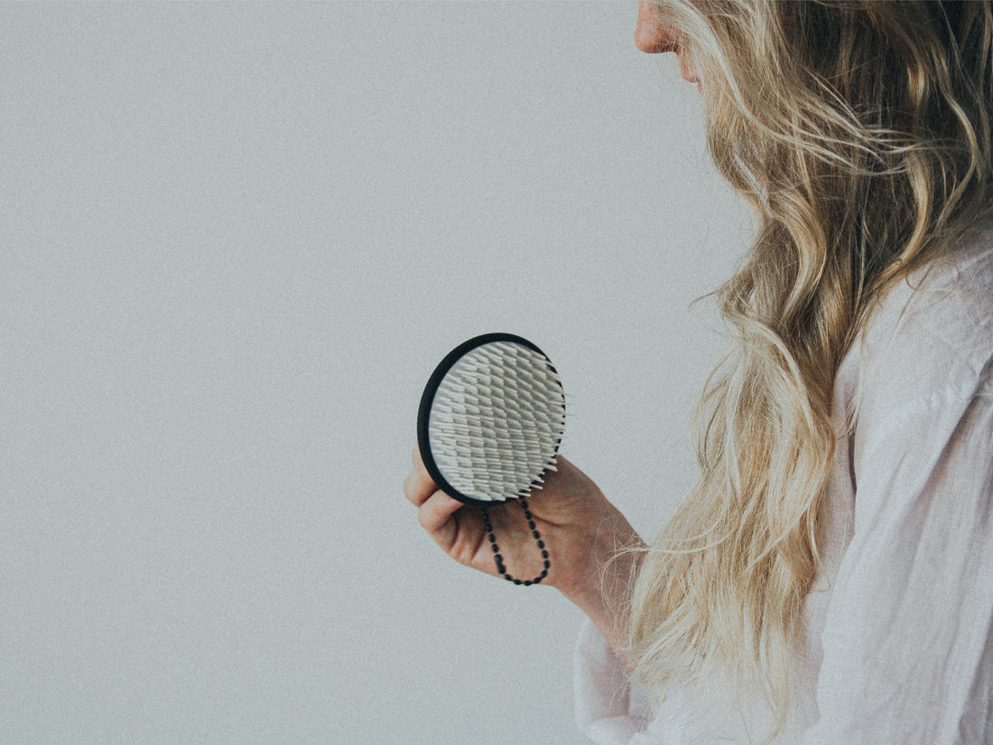 Photo of a woman holding the scalp brush
