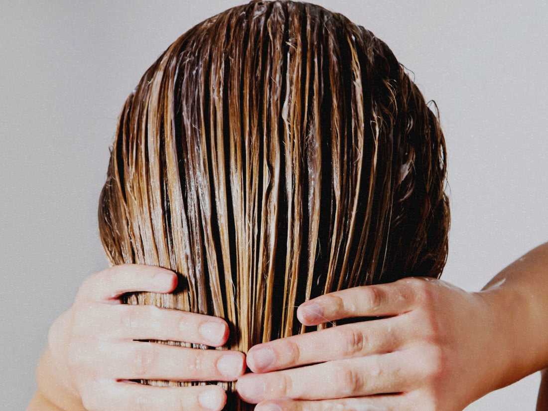 Image of a woman applying conditioner to her hair