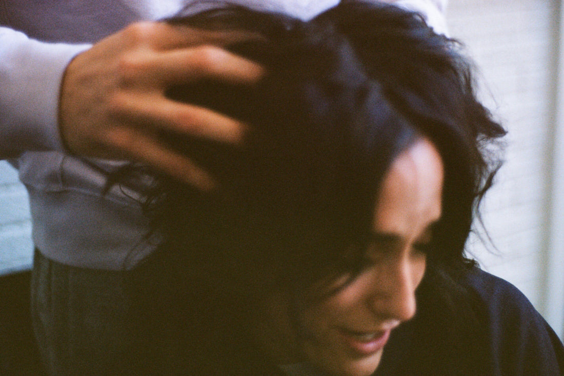 Photo of a woman with another person fluffing her hair