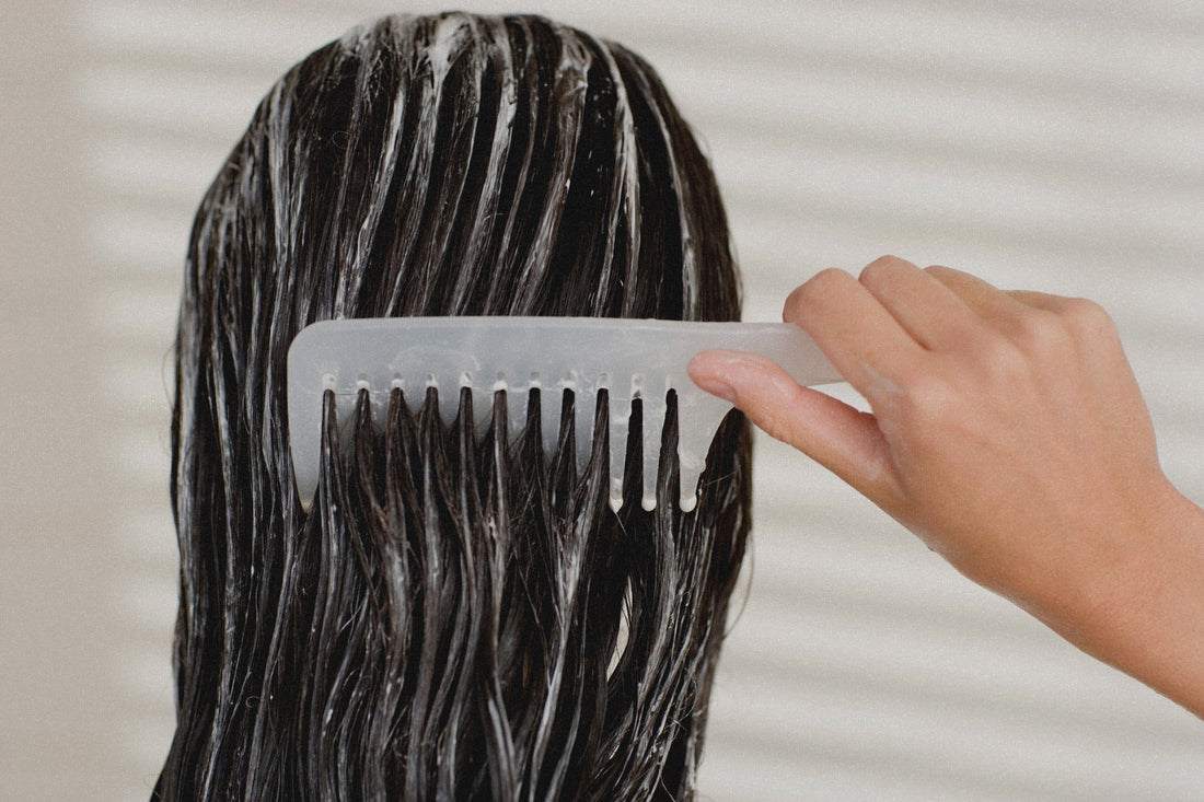 Photo of a woman combing her shampooed hair