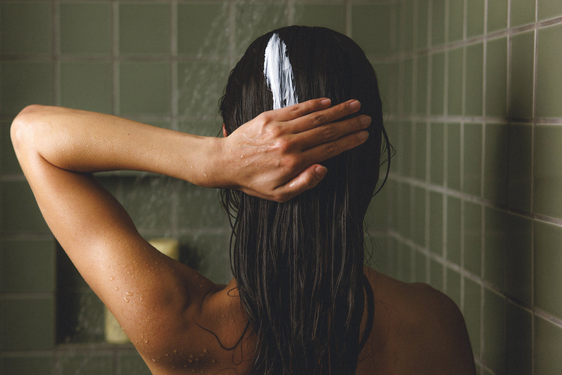 Image of a woman shampooing her hair in the shower
