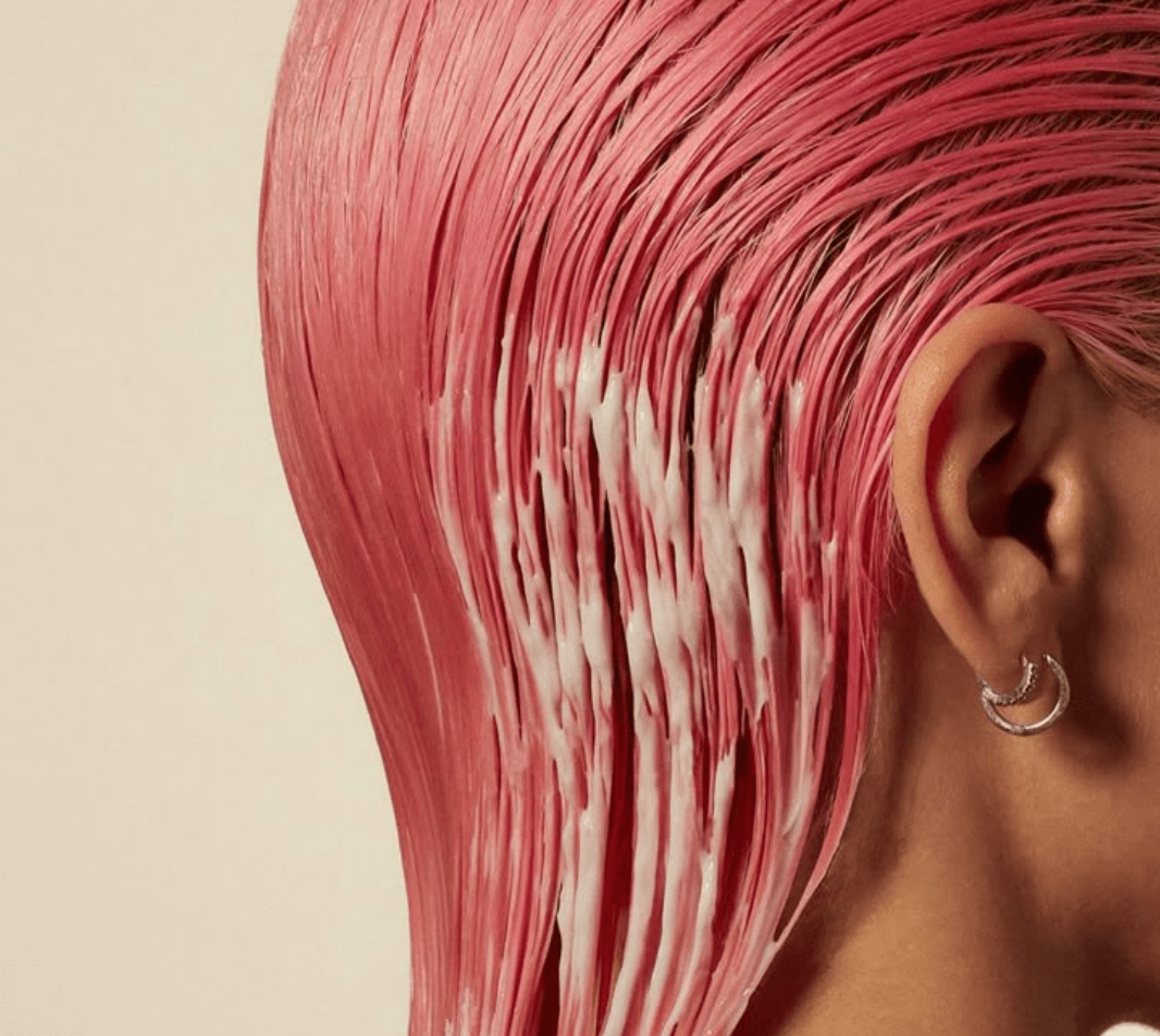 Image of woman with shampoo on her pink hair