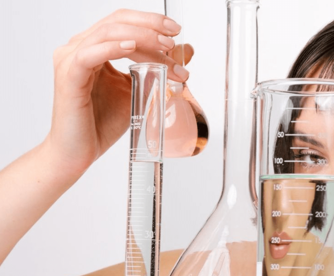 Image of woman holding beakers and flasks