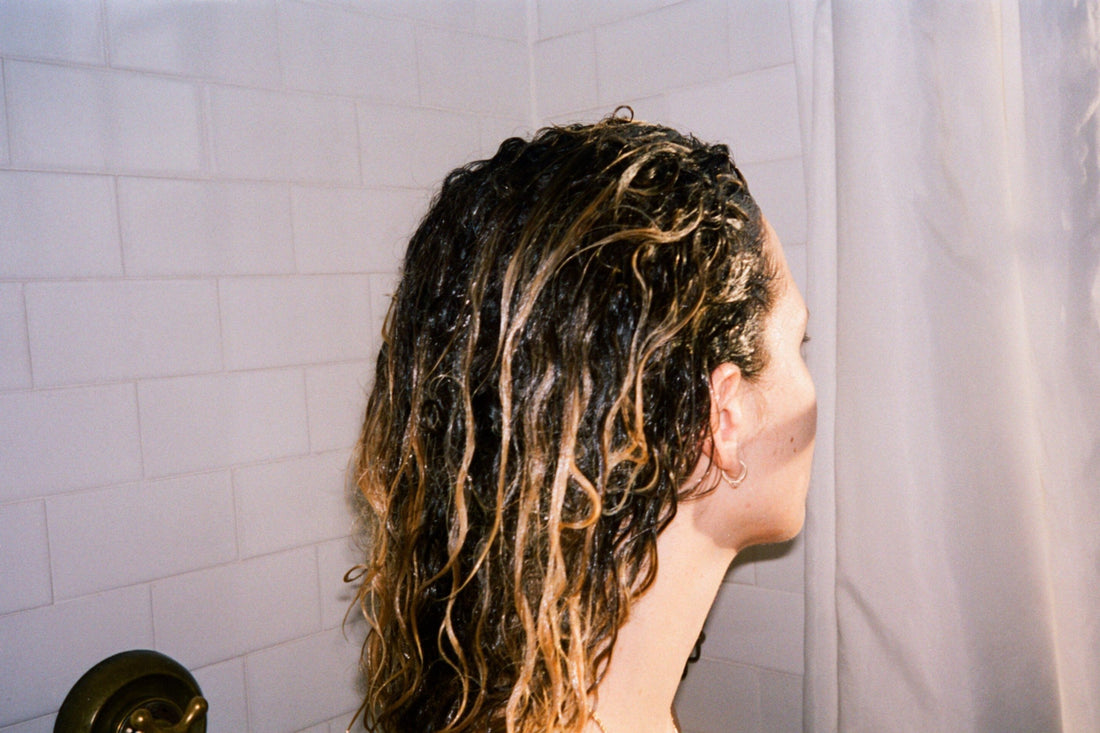 Image of woman with wet, curly hair in the shower