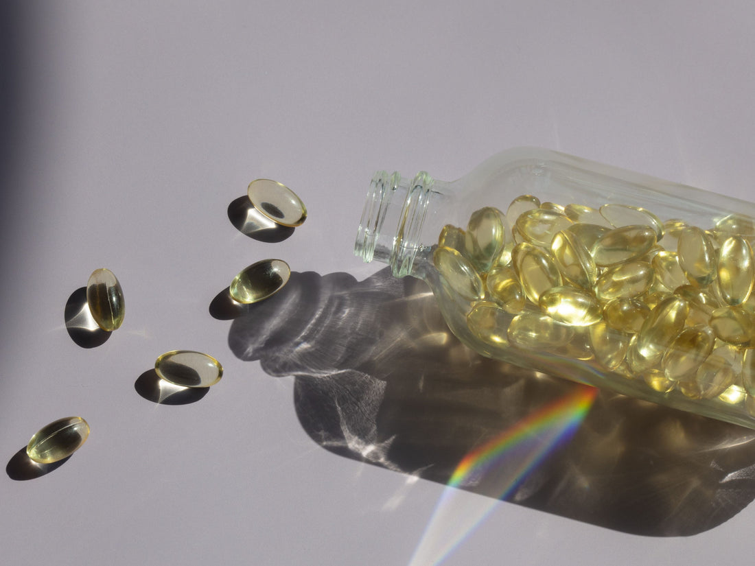 Photo of Vitamin E capsules spilling from a clear, glass bottle