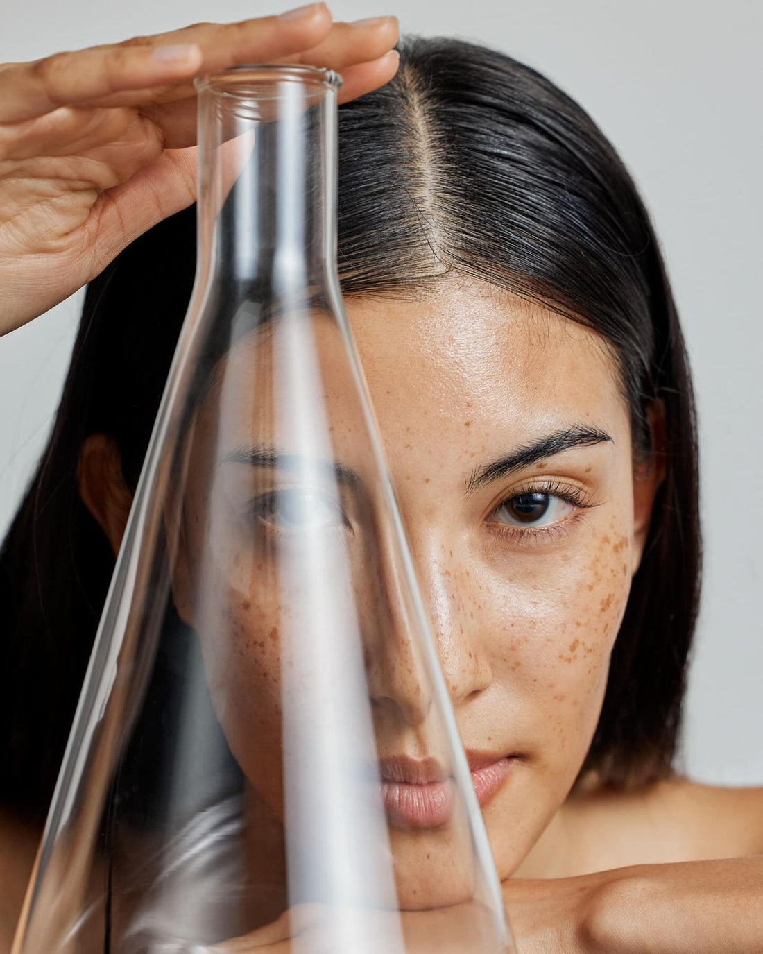 Image of a woman holding up a large laboratory flask