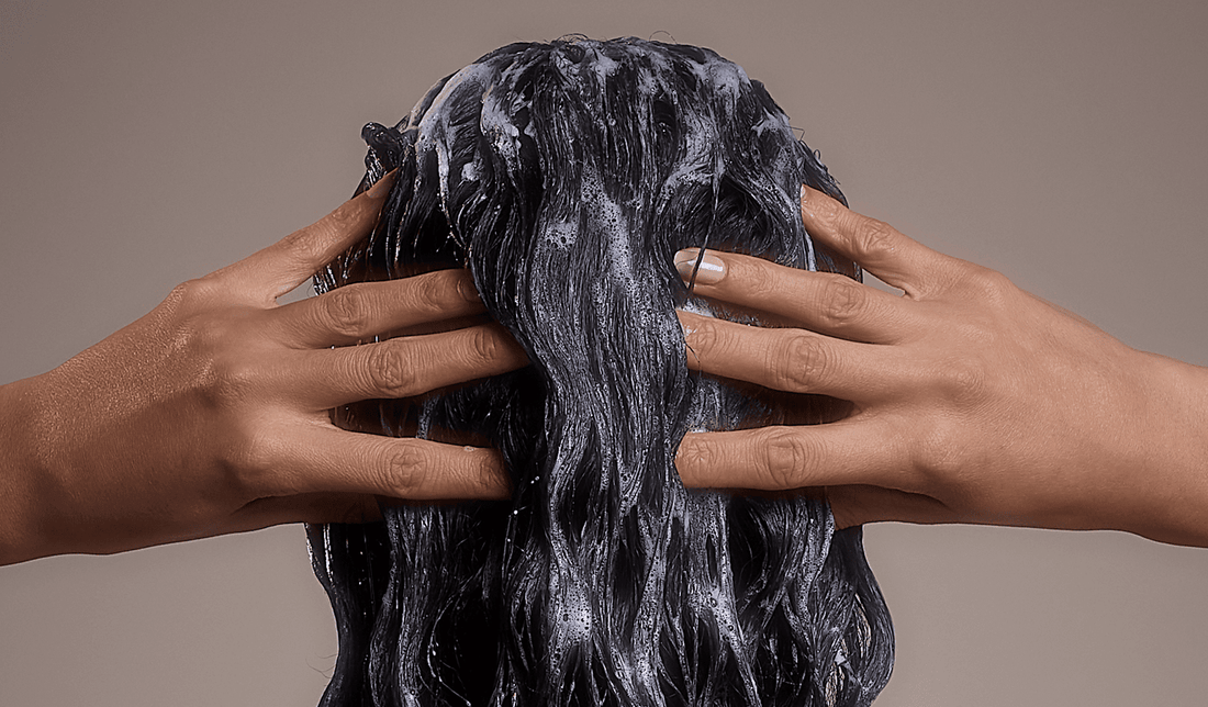 Image of woman shampooing her long, black hair
