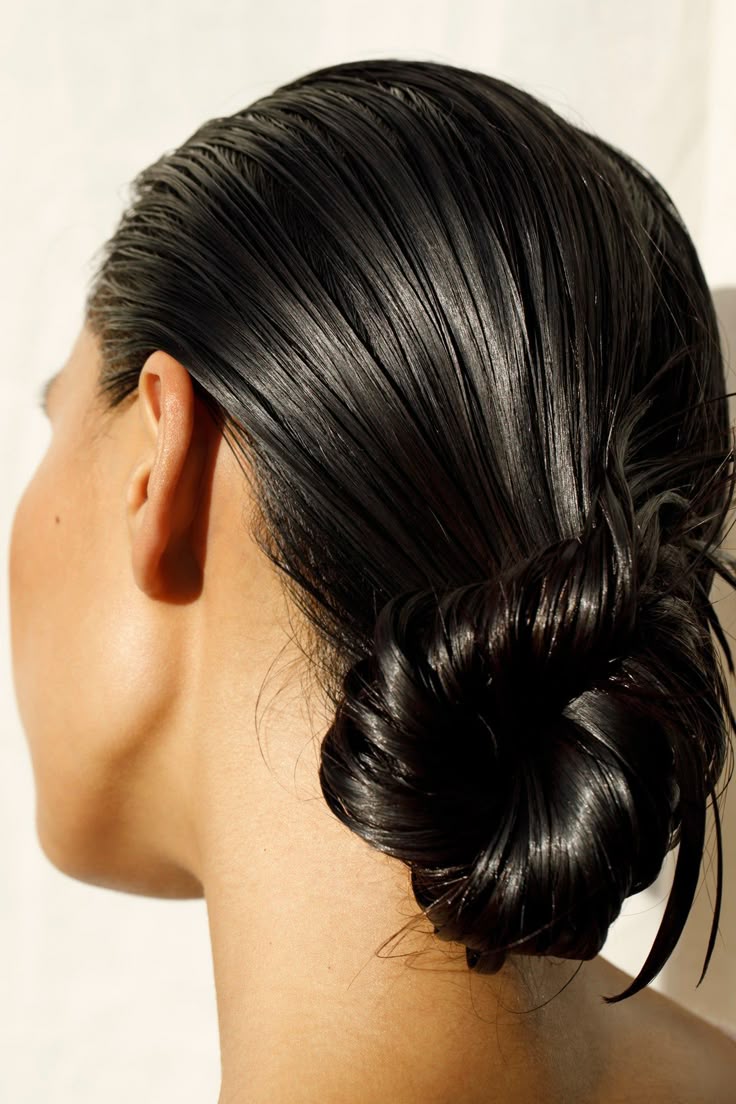 Photo of a woman with her long, black hair in a loose bun